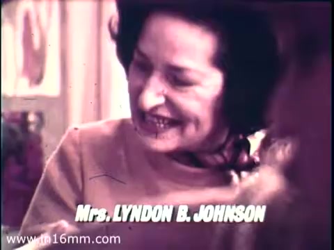 The still from the 1968 PSA features Lady Bird Johnson, notable for her warm demeanor. She is captured smiling, engaging with a child, likely highlighting her advocacy for the Head Start program. The text reading 'Mrs. LYNDON B. JOHNSON' is prominently displayed, framing her identity as First Lady. The vintage aesthetic reflects the era's film quality, contributing to the historical significance of the moment. This image encapsulates her commitment to early childhood education and community support.   Follow us on Twitter @FromFilm for more insights!