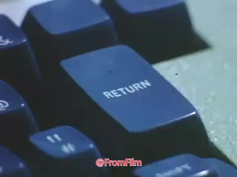 The still shows a close-up of a keyboard key labeled 'RETURN,' likely referencing early computing technology from the late 1960s. Punched cards and a hard copy terminal are indicative of the era's data entry methods. This reflects Point Park College's efforts to showcase its technological and educational advancements during that time.