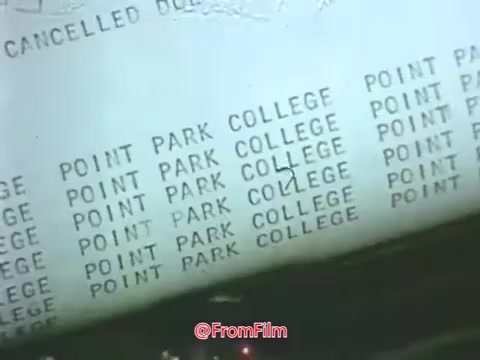 The still from the 1969 Point Park College PSA features a printed hard copy terminal output displaying the repeating text 'POINT PARK COLLEGE.' This highlights the era's technology, showcasing punched cards and early computing methods. The context reflects Point Park College's identity as a liberal arts institution in Pittsburgh, which later became Point Park University in 2004 to accommodate its expanded graduate offerings.