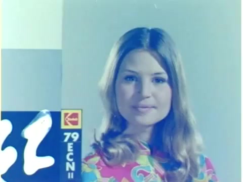 The still from '16mm leader China Girls' features a young woman with long hair, dressed in a vibrant, patterned top. This image serves as a color reference for film lab technicians to assess and calibrate the color accuracy of the film during processing. The background appears muted, highlighting the subject’s bright attire. The film stock is identified, indicating it is Kodak 79 ECN II.