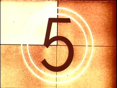 The still from '16mm leader China Girls' features a frame showing the number '5' in a large, bold font, encircled by concentric rings. The background has a warm, faded tone typical of vintage film stock. This type of imagery was commonly used in film lab processing to test color and film quality, serving as an essential reference during production.