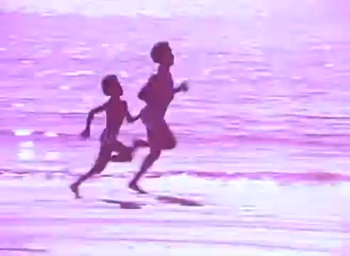The still depicts two figures, a child and an adult, running joyfully along a beach, with the ocean in the background. The scene is bathed in a soft, pinkish hue, creating a warm and nostalgic atmosphere. This imagery likely emphasizes themes of health, vitality, and the importance of taking care of oneself for loved ones, in line with the context of taking blood pressure medication.