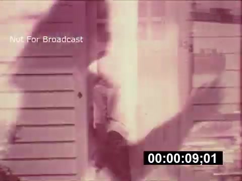 The still from the 1968 Maxwell House Coffee commercial 'The Father's Story' features a nostalgic scene where a figure appears to be stepping out of a house. The visual is characterized by a vintage aesthetic, with a pinkish hue and a soft focus that enhances its retro feel. The presence of the text 'Not For Broadcast' implies this is an archival piece meant for private viewing. The overarching tone suggests a sentimental approach to storytelling, likely highlighting familial themes associated with enjoying coffee.