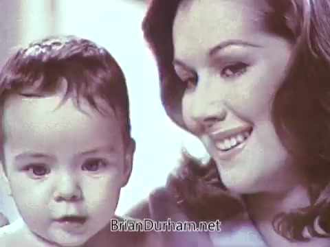 The still from the 1968 Ivory Soap commercial features a smiling woman alongside a baby. The warm colors and soft focus create a gentle, inviting atmosphere, suggesting themes of care and affection. The motherly interaction emphasizes the product's connection to family and hygiene.