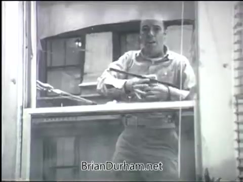 The still from the 'Clean Air PSA - 1968' depicts a man looking out from a window, appearing concerned or contemplative. The image is in black and white, emphasizing a serious tone. The context likely relates to advocating for clean air and raising awareness about pollution's impact on health and the environment. The man's expression suggests a call to action regarding air quality issues.