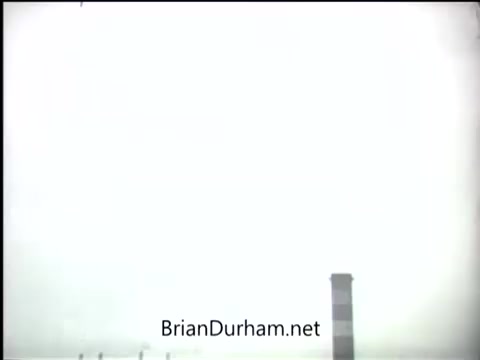 The still from the 'Clean Air PSA - 1968' features a stark, overexposed sky that appears mostly white. In the foreground, a tall industrial smokestack rises prominently, suggesting a connection to air pollution issues. The scene conveys a sense of environmental concern, likely in relation to clean air advocacy.