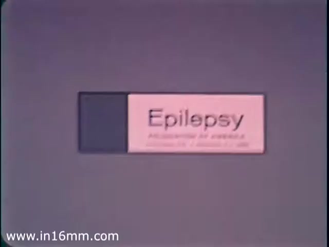 The still features a pink and black slide with the word 'Epilepsy' prominently displayed. It seems to be part of a public service announcement (PSA) from 1968 intended to raise awareness about epilepsy. The design is simple and direct, aimed at conveying a serious message in a clear manner. The context suggests a focus on educating the public and dispelling misconceptions about epilepsy.