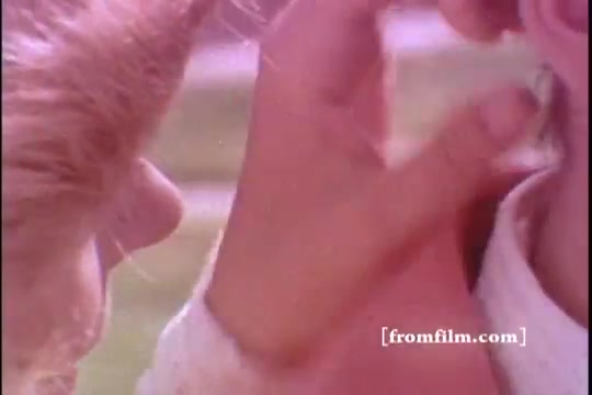 The still from the 16mm print of 'Bold Detergent - 1970's' features two individuals in close proximity, with a focus on a child's hand gently touching another person's face. The image has a warm, soft color palette typical of the era, suggesting a domestic or familial context. The expressions and gestures imply a moment of care or affection, aligning with the brand's messaging around cleanliness and family connections.