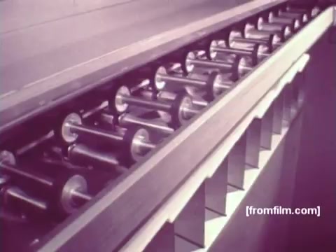 The still from 'IBM: Once Upon A Punched Card' (1964) depicts a mechanical assembly line, likely showcasing the inner workings of punched card technology. The image features a series of rotating rollers, emphasizing the intricate machinery involved in processing punch cards. This scene highlights the era's vintage computing methods, illustrating the transition from manual to automated data handling. The 16mm print captures the nostalgic tones of early computing history, reflecting innovation in data processing systems of the time.   Follow us on Twitter @FromFilm.