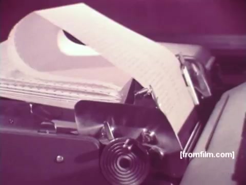 The still from 'IBM: Once Upon A Punched Card (1964)' captures a close-up view of an early computing device, likely a card punch or a similar machine. A lengthy roll of paper is visible, suggesting data being processed or printed, with the focus on the intricate mechanics of computing technology from that era. The soft color palette emphasizes the vintage feel, connecting viewers to the origins of data processing and storage.   Follow us on Twitter @FromFilm.