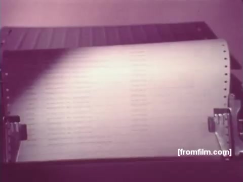 The still from 'IBM: Once Upon A Punched Card (1964)' features a close-up of a punched card being processed, showcasing the machinery involved in early computing. The card is partially unspooled, emphasizing the intricate character patterns. The overall presentation highlights the significance of punch cards in data processing during this era, marking a pivotal moment in the evolution of computing technology.   For more insights, follow us on Twitter @FromFilm.