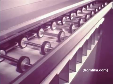 The still from 'IBM: Once Upon A Punched Card (1964)' showcases a series of cylindrical rollers in a machine, likely part of an automated system for processing punch cards. This image highlights the technology of the era, emphasizing the mechanical efficiency of punch card systems that were foundational to early computing. The 16mm print captures the industrial aesthetic of vintage computing, reflecting IBM's role in the evolution of data processing.   Follow us on Twitter @FromFilm.