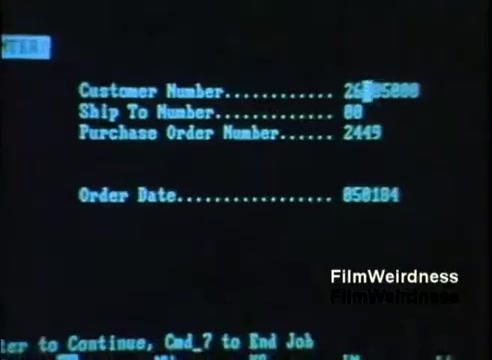 The still features a computer screen displaying a data entry interface, likely from an IBM System 36. It shows fields such as 'Customer Number,' 'Ship To Number,' 'Purchase Order Number,' and 'Order Date,' along with a command prompt at the bottom suggesting actions for the user to continue or end the job. The interface uses simplistic text-based graphics typical of the era, indicative of 1980s technology.