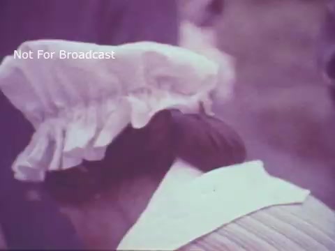 The still from the 'Molly Pitcher Bicentennial Savings Bonds PSA' shows a woman with her back to the camera, wearing a traditional white bonnet and a light-colored dress. The focus is on the bonnet and part of her hairstyle, suggesting a historical or reenactment context. The image has a soft color palette typical of 16mm film. The text 'Not For Broadcast' indicates it may be archival material.