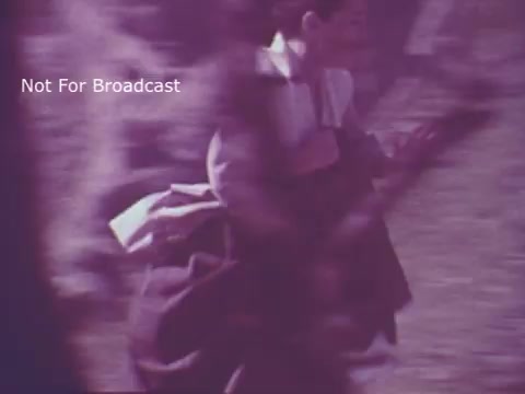 The still from the 'Molly Pitcher Bicentennial Savings Bonds PSA' features a historical representation of a woman in period clothing, depicted in motion, with a focus on her urgency. The image has a soft, vintage quality, likely reflecting the film's 16mm origins. The context suggests themes of patriotism and support for savings bonds, tied to the American Bicentennial celebration.
