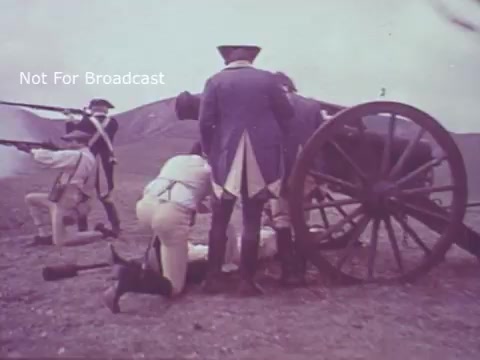 The still from the 'Molly Pitcher Bicentennial Savings Bonds PSA' depicts a historical scene likely set during the American Revolutionary War. Soldiers are shown operating a cannon, with one figure appearing to load it while others stand by, prepared for action. The clothing is reminiscent of the 18th century, emphasizing the historical context. The image likely aims to evoke patriotism and honor the contributions of figures like Molly Pitcher during the war.