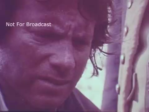 The still from the 'Molly Pitcher Bicentennial Savings Bonds PSA' features a close-up of a man with an intense expression. His face appears weathered, suggesting a narrative of struggle or concern, likely related to the themes of sacrifice and patriotism associated with Molly Pitcher's historical legacy. The muted color palette enhances the somber mood, aligning with the serious message of the PSA.