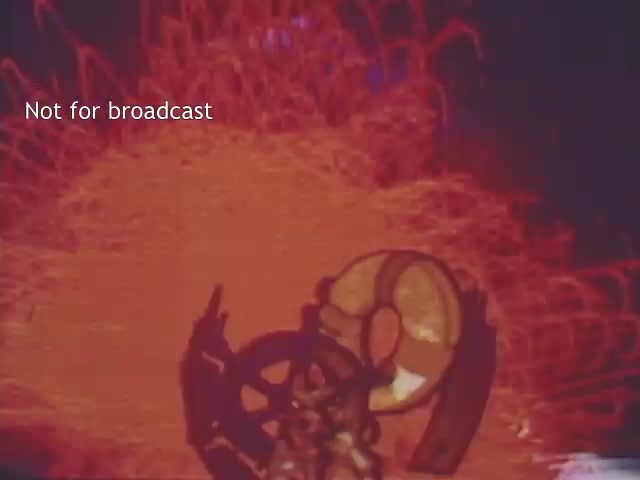 The still from the 1970s US Coast Guard Boating Safety PSA features a visually striking scene dominated by swirling, vibrant reds and hints of other colors in the background. In the foreground, a lifebuoy is prominently displayed, suggesting a focus on boating safety. The overall aesthetic can be described as retro and somewhat dramatic, typical of the era’s public service announcements, aiming to capture attention and convey important safety messages.