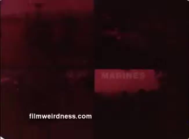 The still from the 16mm PSA titled 'Employers Support the Guard and Reserve' depicts a segmented frame, primarily featuring a red tint. One section prominently displays the text 'MARINES.' Overall, the image conveys themes of military support and the importance of employer backing for service members during the 1980s. The color and composition suggest a vintage presentation style typical of that era's public service announcements.