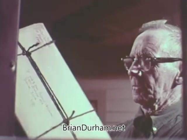 The still from the 1968 Christmas Seal PSA features an elderly man carefully examining a package tied with string. He is wearing glasses and a button-up shirt, emphasizing a thoughtful demeanor. The scene likely conveys a message about the importance of giving, particularly in the context of holiday charity and health awareness associated with the Christmas Seal campaign.