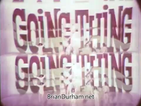 The still features a colorful text overlay with the words “GOING THING,” prominently displayed. It likely captures the playful and energetic spirit of the 1968 Ford Mustang commercial featuring Arte Johnson in character from 'Laugh-In.' The design is reflective of the vibrant styles of late 1960s advertising, aimed at grabbing viewers' attention during the Ford Pop-Option sale. The intended airing was on WTRF in Wheeling, West Virginia.