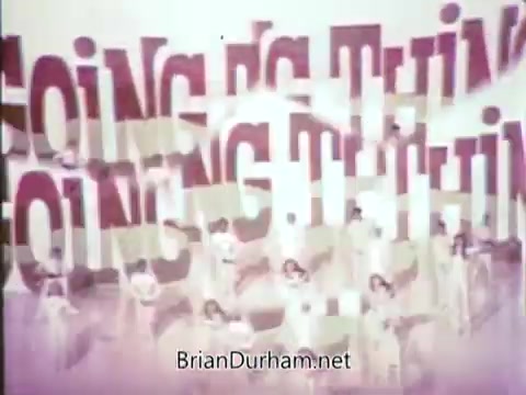 The still from the 1968 Ford Mustang commercial features bold, vibrant text that reads 'Going Thing,' likely emphasizing the appeal of the Ford Pop-Option sale. Arte Johnson, in character from 'Laugh-In,' adds a comedic element to the commercial, enhancing its entertainment value. The background may feature dancers or performers, contributing to a lively atmosphere. The context highlights an energetic promotion aimed at engaging viewers and driving interest in the Mustang offering on WTRF in Wheeling, West Virginia.