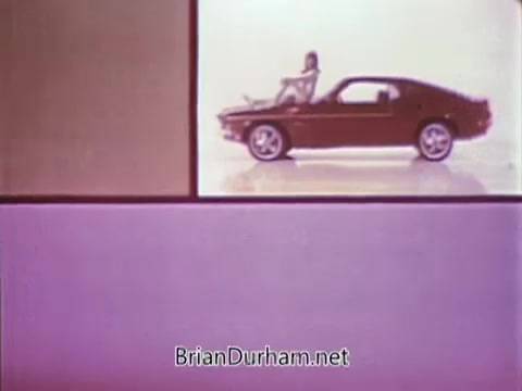 The 16mm still from the 1968 Ford Mustang commercial features a split layout, with a young woman casually posed next to a stylish red Mustang on one side and a colorful, minimalist background on the other. Arte Johnson, known for his character work on 'Laugh-In,' is likely adding humorous commentary or antics related to the Ford Pop-Option sale, aiming to engage viewers with a lighthearted tone. The ad was intended for WTRF in Wheeling, West Virginia, highlighting the appeal of the Mustang during that era.