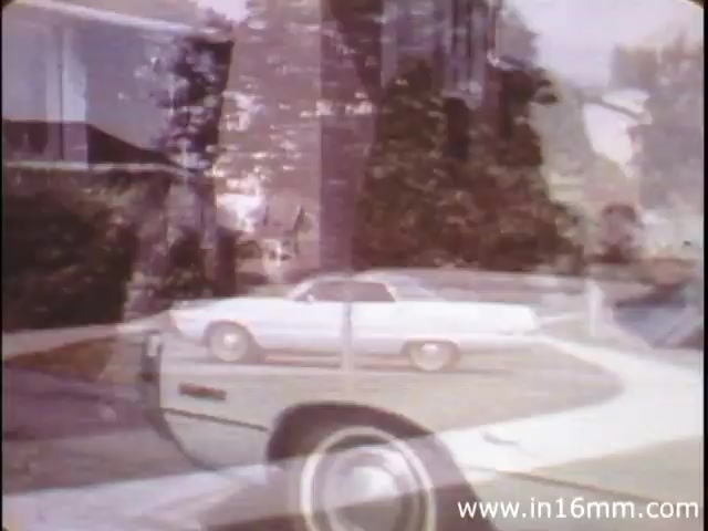 The still from 'I Am Joe's Stomach' features a blend of live-action and animation to illustrate the complex functions of the human stomach. The image captures a suburban scene, likely setting the stage for the story, with a notable white car parked in front of a house. This animated narrative emphasizes Joe's experiences related to digestive health, incorporating educational elements about the stomach's care and its critical role in the body's digestive process amidst everyday life challenges. The stylistic choice of overlaying live-action and animation suggests a creative approach to engaging viewers in health education.