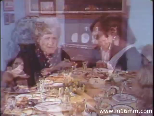 The still from 'I Am Joe's Stomach' features a dinner scene where several people are gathered around a table filled with food. The ambiance appears cozy, typical of a family gathering. The characters are engaged in conversation, likely discussing the meal, which ties into the film's focus on the human stomach and digestion. Utilized in the 1980s version by Reader's Digest, the film combines animation with live-action to illustrate the functioning of the stomach, particularly stressing the importance of dietary choices and their impact on health.