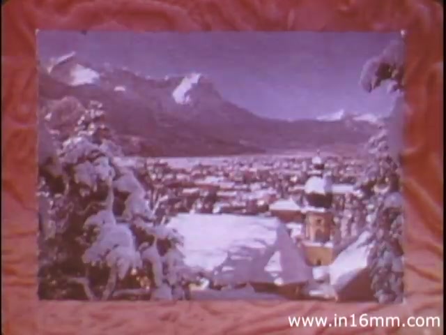 The still from 'I Am Joe's Stomach' features a picturesque winter landscape, showcasing a snowy town surrounded by majestic mountains. The image is framed with a visually striking, textured border, reminiscent of stomach or digestive motifs. This setting serves as a backdrop for exploring the functions of the human stomach through animation and live sequences, aiming to educate viewers on digestive health and the consequences of dietary choices, symbolized by the character Joe. The use of vibrant colors and contrasting snowy scenes highlights the film's educational yet engaging approach.
