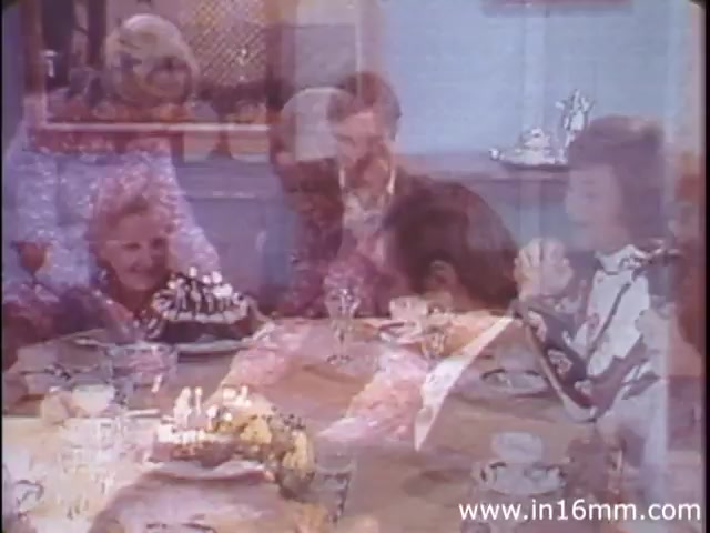The 16mm still from 'I Am Joe's Stomach' (1980s version) depicts a lively dinner scene, likely celebrating a special occasion with a group of people gathered around a table. The atmosphere appears joyful, with decorations and a dessert centerpiece suggesting a festive meal. This context complements the film's exploration of the human stomach's functions and challenges, linking the social experience of dining to the biological processes it entails. The use of animation and live-action likely illustrates the interplay between these experiences and the comedic yet educational narrative regarding digestive health.