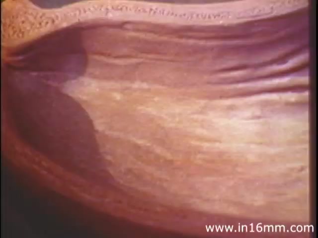 The still from 'I Am Joe's Stomach,' a 1980s film by Reader's Digest, showcases a close-up view of a colorful, textured representation of the human stomach. This animated sequence highlights the stomach’s intricate structure, emphasizing its muscular and flexible nature. The film employs a blend of three-dimensional animation and live-action footage to illustrate the stomach's functions and care, presenting the narrative through a personified character experiencing digestive challenges. Overall, the visual captures the essence of digestion and bodily function in an engaging and educational manner.