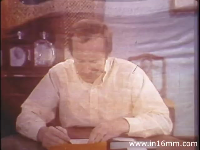 The still from 'I am Joe's Stomach' depicts a man in a light-colored shirt, shown in a moment of contemplation as he writes. The scene is likely set in a cozy, domestic environment, with hints of warmth and familiarity in the background. The film combines 3D animation and live-action sequences to illustrate the complex functions of the human digestive system, focusing on Joe's experiences with stomach-related issues, emphasizing the importance of digestive health.