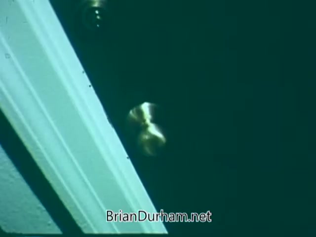 The still from the 'Point Park College PSA' features a close-up of a door with a brass doorknob. The angle captures the edge of the doorframe, creating a sense of anticipation as if someone is about to enter. The overall tone of the image is subdued, possibly indicating a serious or reflective moment related to the college's message.