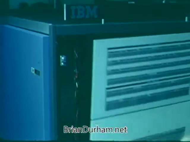 The still from the 'Point Park College PSA' features an IBM computer system prominently displayed. The image captures the details of the machine, including its design and cooling vents, suggesting a focus on technology and innovation in the academic environment. The overall tone is likely to convey the importance of computing and technology in education.
