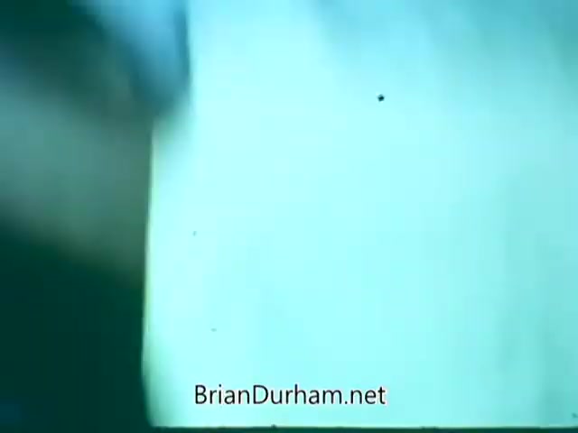 The still from the 'Point Park College PSA' displays a blurred hand motion, possibly indicating action or movement, near a light background. The image appears slightly distressed, typical of older 16mm film, featuring a soft focus and warm tones. Overall, it suggests an engaging moment related to the college's promotional message.