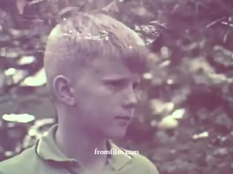 The still features a young boy with a light-colored shirt, standing in a natural setting. His expression is serious as he gazes off-camera, surrounded by foliage that suggests an outdoor environment. The colors are notably faded, typical of a 1967 16mm print, giving the image a nostalgic feel. The context implies a focus on the importance of pesticide awareness and safety.