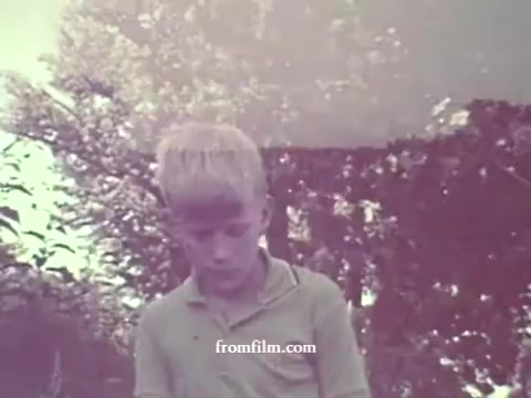 The still from the 1967 Pesticides PSA features a young boy with light blonde hair, looking down thoughtfully. The colors are significantly faded, creating a muted, nostalgic ambiance. The background includes blurred greenery, suggesting an outdoor setting. The overall tone conveys a sense of innocence and curiosity, typical of public service announcements aimed at educating about pesticides.