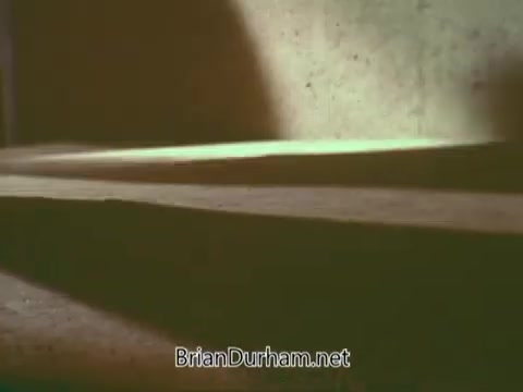 The still from the 'Boy Scouts PSA - 1960's' features a close-up view of the ground, showing textured surfaces and shadows. The lighting appears soft, creating a nostalgic atmosphere typical of that era. The warm tones contribute to the overall vintage feel of the image.