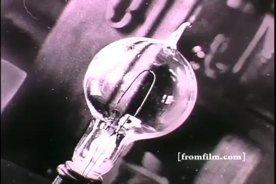 The still features a close-up of an incandescent light bulb, capturing the intricate details of its glass envelope and filament. This image likely symbolizes innovation and progress, reflecting Thomas Edison's contributions to electrical lighting. The monochrome aesthetic is consistent with early 20th-century film, emphasizing the historical context.