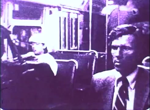 The still from the 16mm trailer of 'The Laughing Policeman' features a tension-filled scene set on a bus. On the left, a bus driver, wearing a cap, is focused on the road, while on the right, a well-dressed passenger appears anxious, reflecting an atmosphere of suspense. The monochromatic tones contribute to a gritty, vintage feel typical of 1970s cinema, hinting at the film's crime and mystery themes.