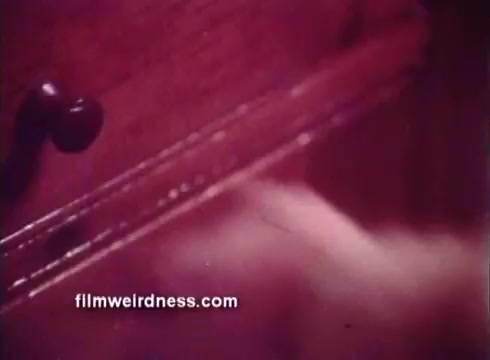 The still from the 1970s Ben Gay commercial shows a close-up of a hand reaching towards a wooden drawer. The lighting is warm, creating a cozy atmosphere. This imagery likely sets the tone for the product's message about pain relief and comfort. The overall aesthetic reflects the era's advertising style, focusing on domesticity and warmth.