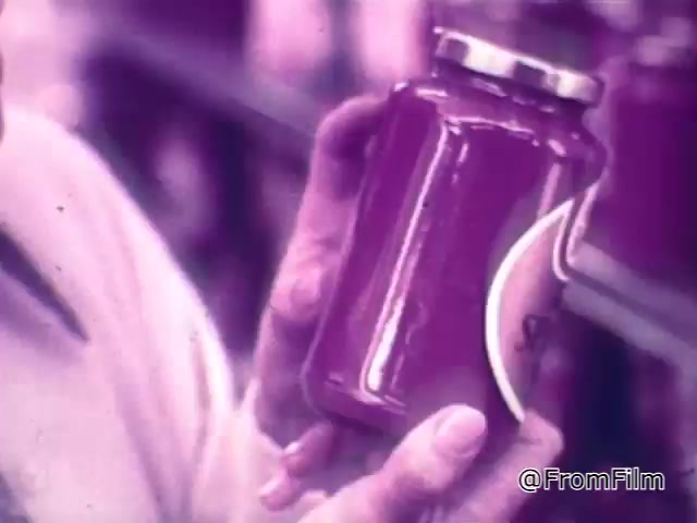 This 16mm still from a 1960s Chef Boyardee spaghetti sauce commercial features a close-up of a person holding a jar of spaghetti sauce. The jar appears rich and robust, emphasizing the visual appeal of the sauce as part of the purchasing decision. The background suggests a grocery store setting, reinforcing the message about selecting quality ingredients. The voiceover highlights the importance of choosing good tomatoes, onions, and meat, and suggests that the same principles apply when selecting spaghetti sauce.