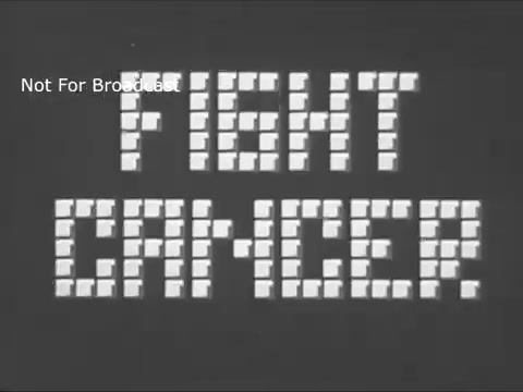 The still from the 1960s American Cancer Society PSA features the bold, blocky text 'FIGHT CANCER' displayed prominently against a simple, monochromatic background. The stark design emphasizes the urgency and seriousness of the message, reflecting the public health campaign's focus on raising awareness and encouraging action against cancer. The overall aesthetic is characteristic of the era's television graphics, aiming for clarity and impact in a concise format.