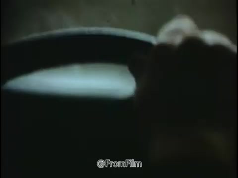 The still from the 1968 National Safety Council PSA focuses on the theme of road safety and the importance of vehicle maintenance, particularly in adverse weather conditions. It captures a hand gripping the steering wheel, suggesting a driver preparing for changes in the driving environment. The dim lighting implies a sense of caution and alertness. The backdrop seems to hint at a rainy or icy road scenario, aligning with the message about hidden dangers posed by poor tire conditions and speed. This visual serves as a reminder to stay vigilant and maintain proper tire care to prevent accidents, emphasizing the need to be 'trap conscious.'