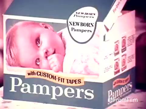 The still features a charming baby inside a Pampers diaper box, showcasing the product prominently. The baby is smiling and sucking on its thumb, exuding innocence and cuteness. The box is designed attractively, emphasizing 'NEWBORN Pampers' and 'with CUSTOM-FIT TAPES,' highlighting the features of the diapers. The overall aesthetic reflects the 1970s advertising style, aimed at appealing to new parents.   For more classic film content, subscribe or follow us on Twitter @FromFilm!