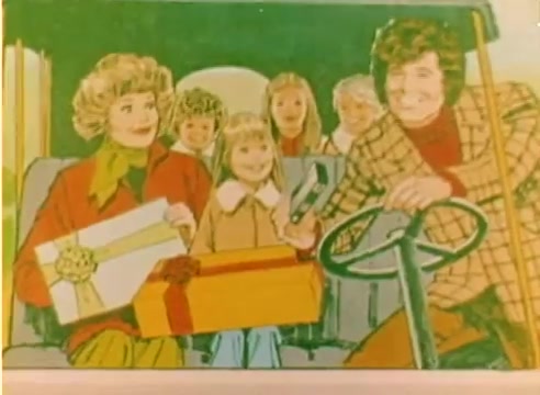 The still features a colorful illustration reminiscent of 1970s animation. It depicts a cheerful scene inside a vehicle featuring two adults—a woman and a man—alongside several children. The adults are holding gifts, suggesting a festive holiday theme. The woman has curly hair and wears a green scarf, while the man, with a distinctive hairstyle, is seen driving. This image reflects the joyful spirit of the Christmas season and appears to be aimed at promoting family-friendly holiday content typical of Kodak's marketing in 1977.