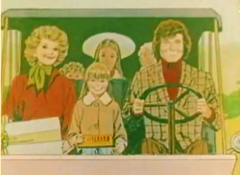 The still depicts a colorful, animated scene featuring a group of cheerful characters in a vehicle, likely associated with a holiday theme. Among them is a man with curly hair in a patterned jacket, and a blonde woman with a scarf. A young girl in a coat is sitting in front, giving a joyful impression. The background hints at a festive atmosphere, fitting for a 1977 Kodak sales film aimed at promoting Christmas. The image emphasizes warmth, family, and celebration, characteristic of the era's holiday promotions.