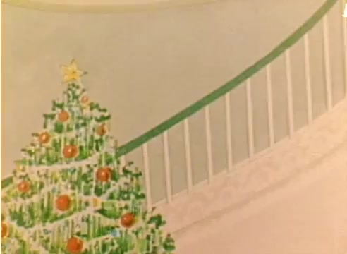 The still depicts a festive scene featuring a brightly decorated Christmas tree adorned with ornaments and a star on top. In the background, a white staircase railing is visible, painted in a soft green hue. The overall aesthetic captures a warm, holiday atmosphere typical of a 1970s Christmas, aligning with the promotional intent of the Kodak sales film. The image's colors are vivid yet slightly muted, characteristic of a vintage 16mm presentation.