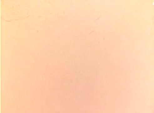 The still from the 'Kodak 1977 Sales Film' features a color negative that appears largely blank with a uniform tint, typical of a silent film workprint. This format would have been used for promotional purposes, likely showcasing Kodak's products during the holiday season, potentially including glimpses of Michael Landon and Dick Van Dyke in a promotional context. The overall aesthetic reflects the film techniques and color processing used in the late 1970s.